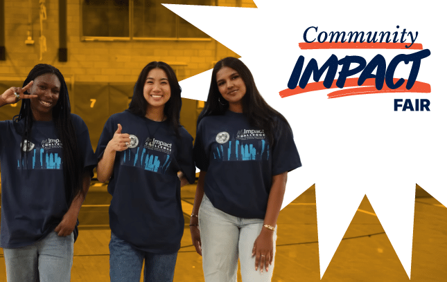 Three young women in matching blue shirts pose together at a Community Impact Fair, with the event's logo displayed.