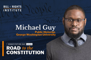 Portrait of Michael Guy, a public historian from George Washington University, with Constitution backdrop.