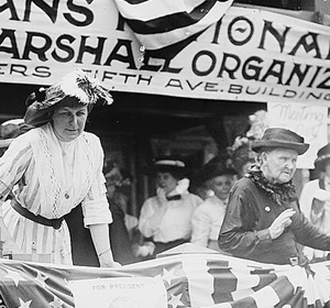 Historical image of women at a rally with banners advocating for veterans' rights and a presidential candidate.