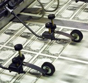 Machine components processing sheets of printed currency in a manufacturing facility.