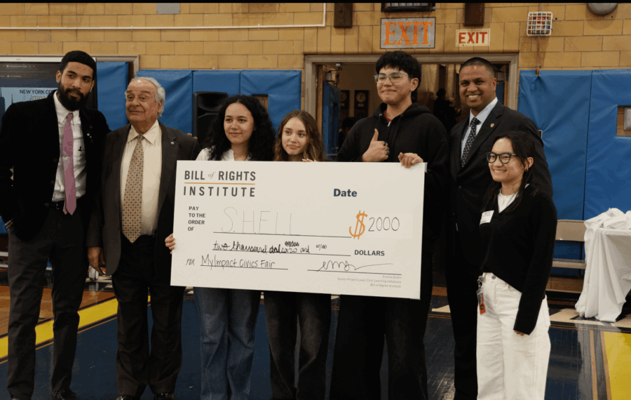 A group of people holding a large check for $2000 at an event hosted by the Bill of Rights Institute.