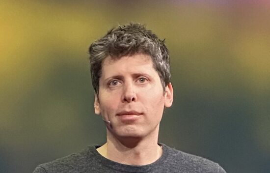 A man with grayish-brown hair wearing a gray shirt, looking directly at the camera.