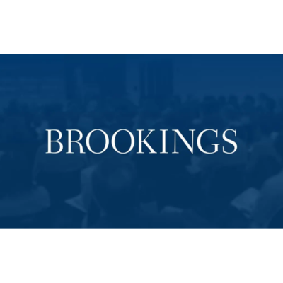 Text "BROOKINGS" on a blue background with an audience blurred in the background.